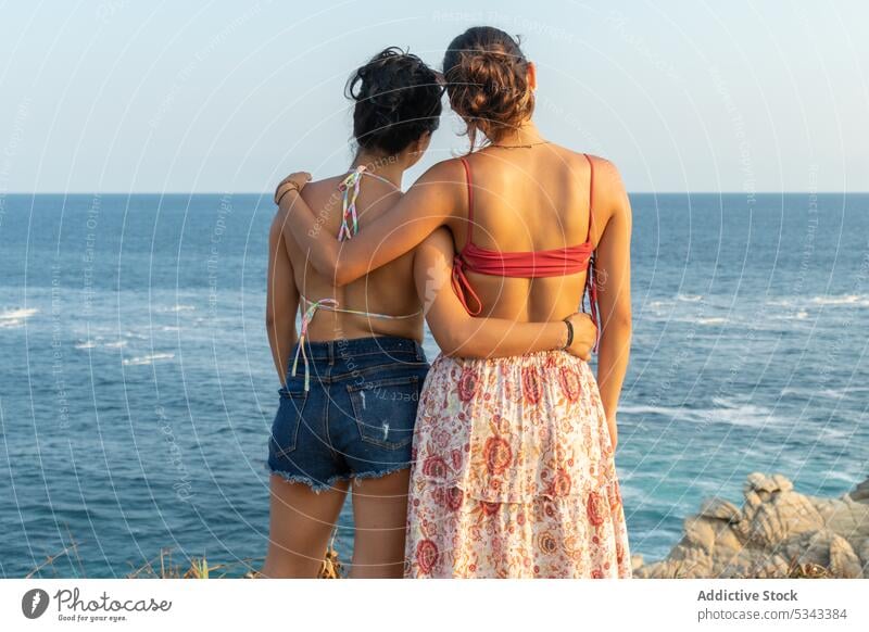 Unrecognizable women hugging against waving sea friend sunset summer vacation coast together wave shore swimwear puerto escondido oaxaca mexico ocean beach rest