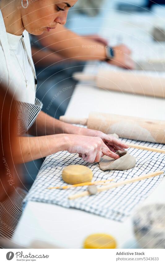 Crop woman making hole in clay on table pottery create artisan craft earthenware workshop clayware handmade skill female craftswoman hobby handicraft crockery