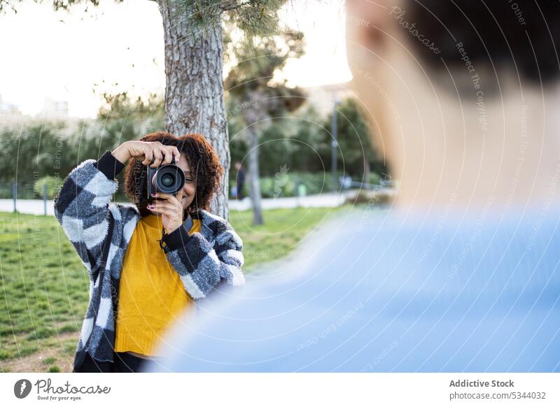 Young woman shooting photos near trees on green grass take photo photo camera photographer park photography hobby professional capture daytime trunk summer