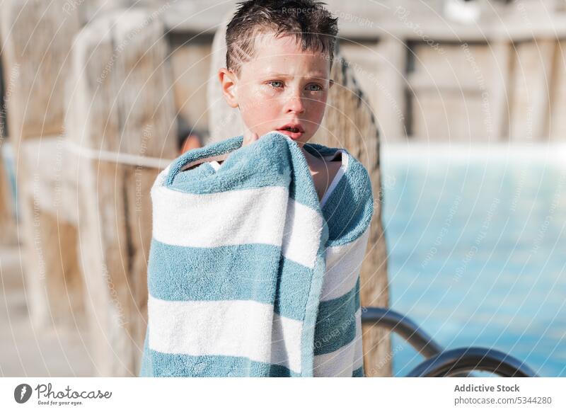 Cute boy in towel on poolside resort summer vacation holiday child fence kid tropical calm rest recreation sun weekend wrap wooden summertime childhood tourism