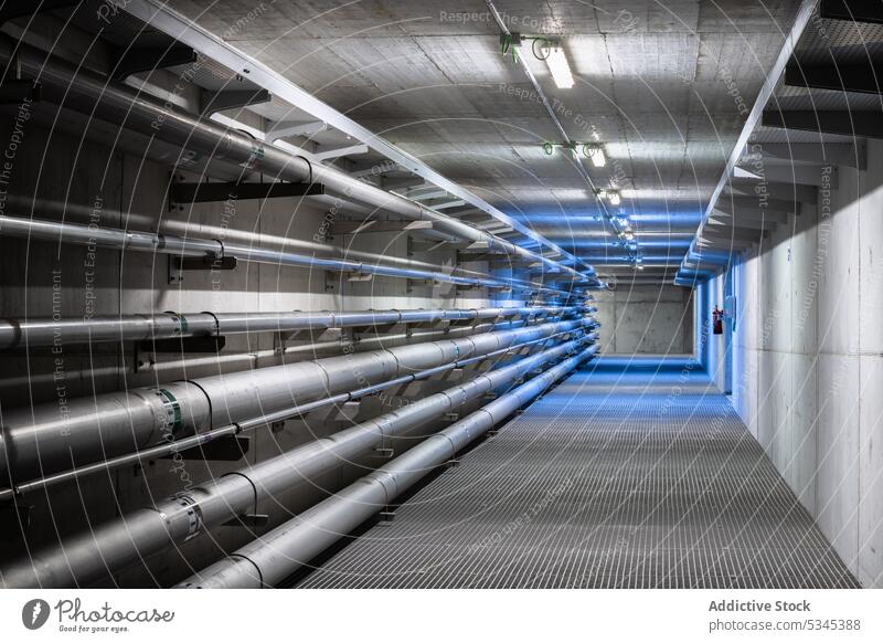 Empty underground tunnel with plumbing pipes corridor water gas pipeline drain system engineering hall basement warehouse boiler heat hvac ventilate electric