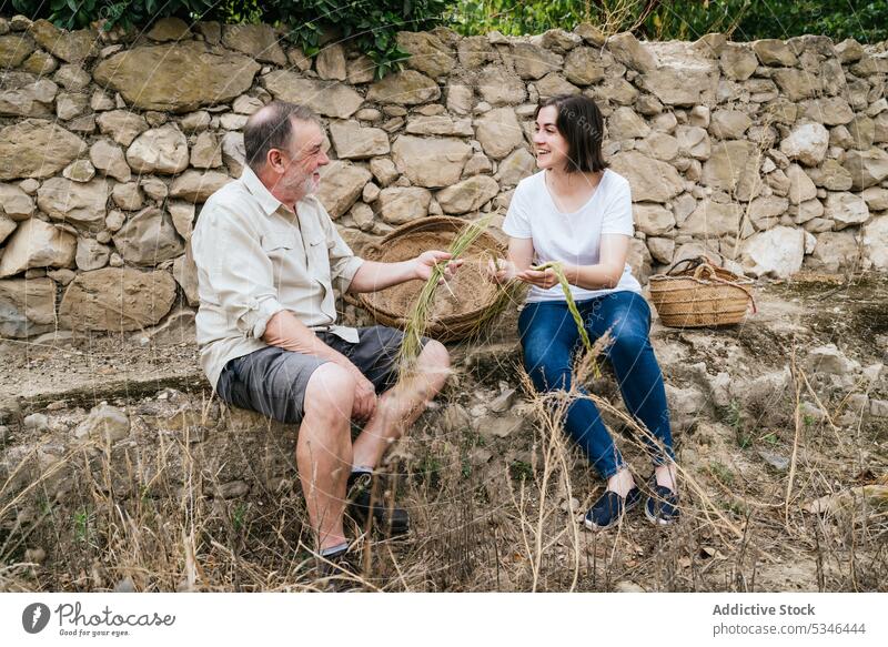 Happy woman with father holding halfah grass for natural fiber crafts esparto collect farmer smile family business harvest gardener prepare daughter