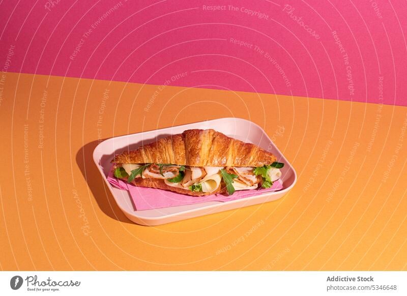 Croissant with ham, cheese and rocket leaves placed on plate croissant pastry bakery breakfast slice baked savory stuffed flavorful morning homemade fresh tasty