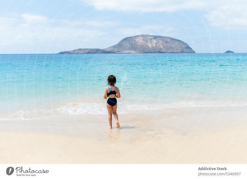 Unrecognizable girl walking on beach sea ocean swimwear swimsuit shore travel wave coast water shoreline faceless paradise relax sand coastline seascape calm