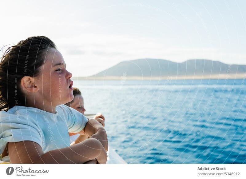 Kids enjoying time on seafront in summer children together beach weekend fence seashore wind relax childhood kid seaside sibling sunlight friendship paradise