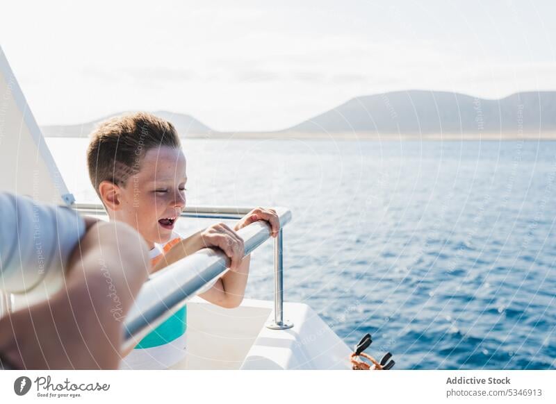 Smiling boy on boat in sea water ship float child smile yacht happy enjoy vacation ocean kid fresh sunlight pleasure glad marine resort positive childhood