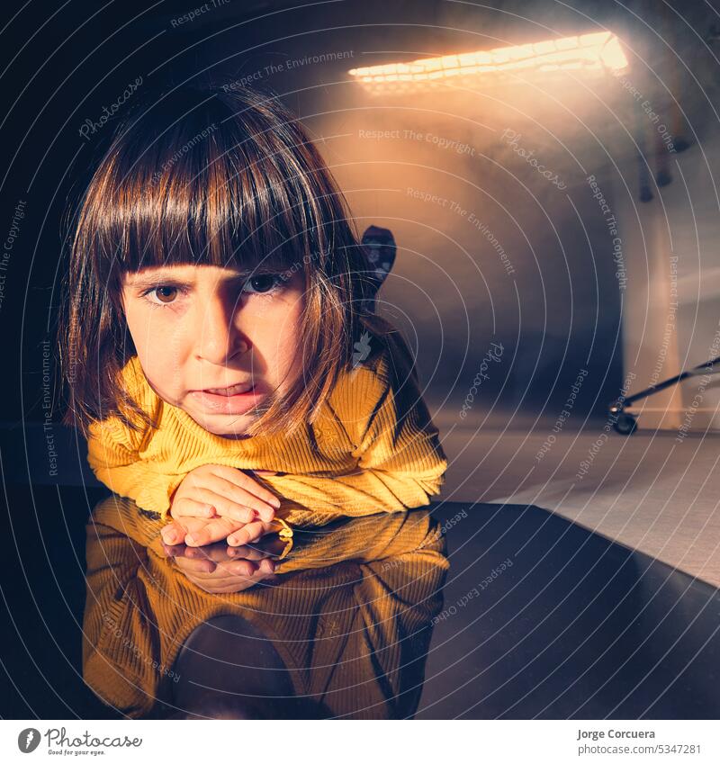 portrait of a girl, lying on the floor of a photography studio, with smoke. square format sad depressed person young woman alone face reflection female sadness