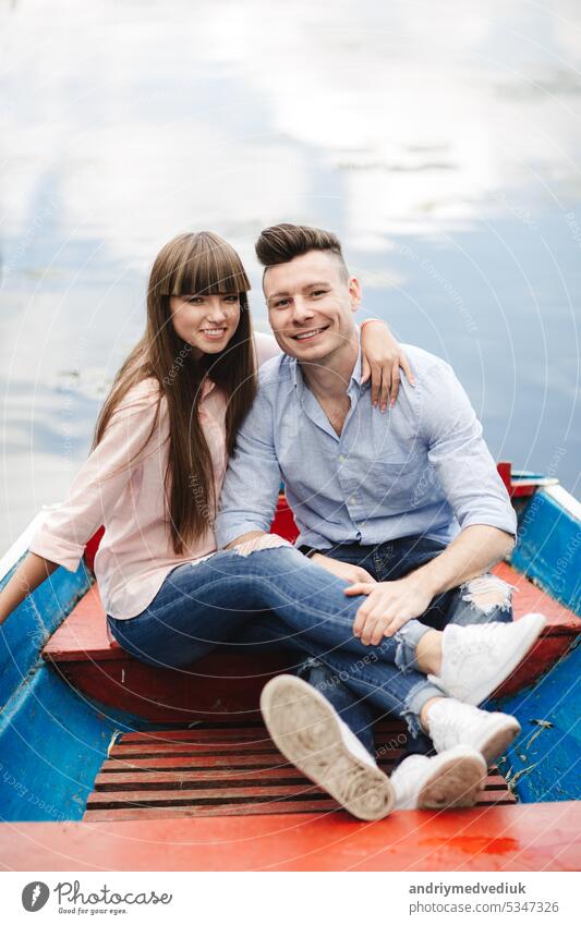 A couple riding a blue boat on a lake. romance. emotional couple. funny and in love young water happy summer river vacation woman ride people beautiful travel