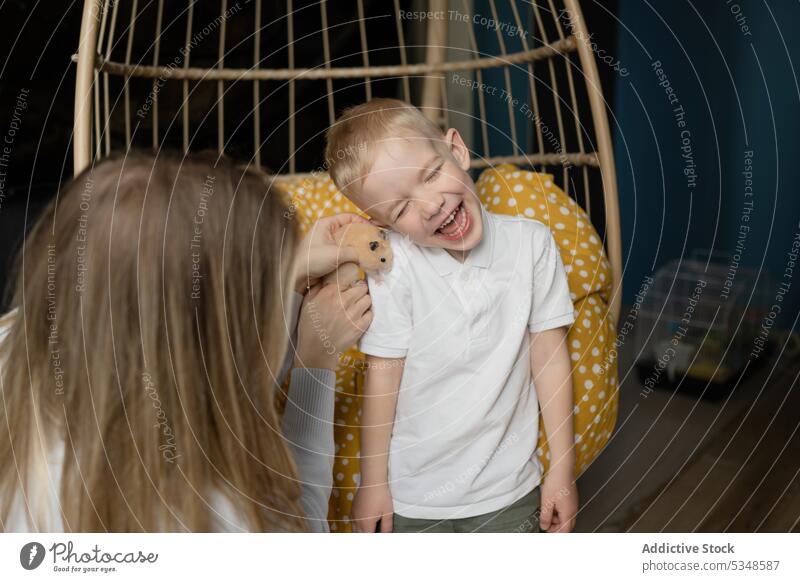 Young woman holding pet and showing to cheerful child kid smile at home companion enjoy curious childhood young son adorable preteen happy glad together friend