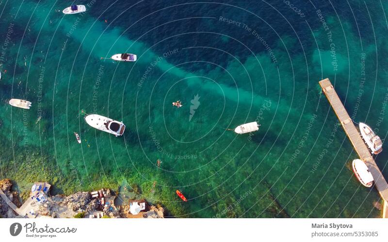 Aerial view of the coast of Mediterranean Sea. Beach resort vacation. Drone view of kayaks, canoes, sups, boats, swimming people in blue water. drone sea