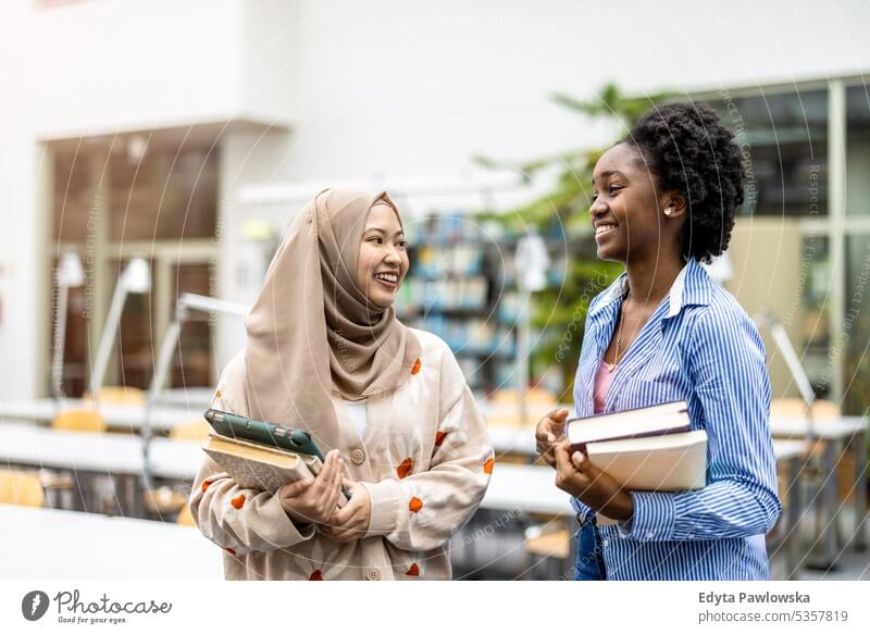 Female students standing together in university library real people teenager campus positive exam knowledge confident academic adult lifestyle academy