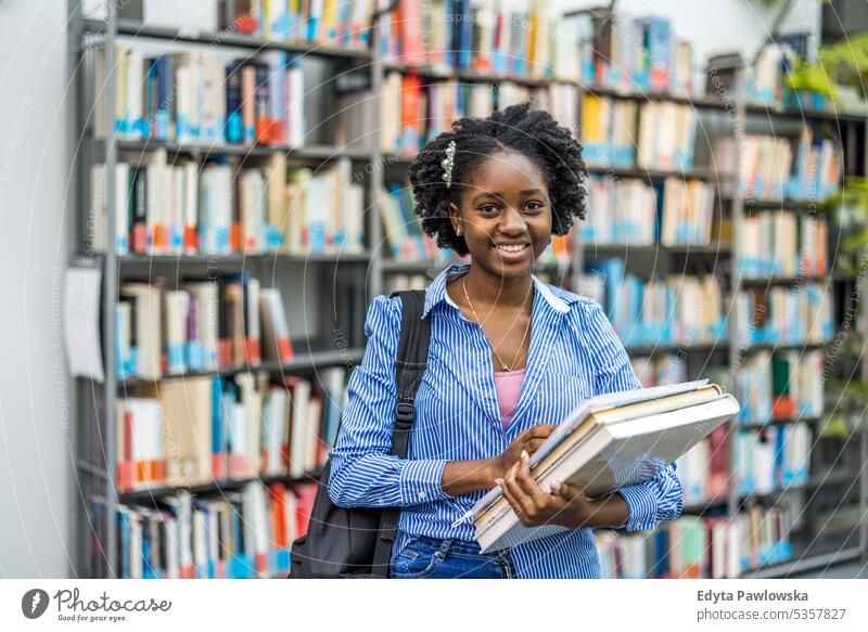 Portrait of black female student standing in a library real people teenager campus positive exam knowledge confident academic adult lifestyle academy adolescent