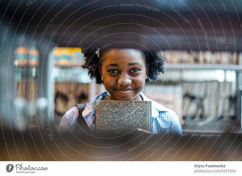 Portrait of black female student standing in a library real people teenager campus positive exam knowledge confident academic adult lifestyle academy adolescent