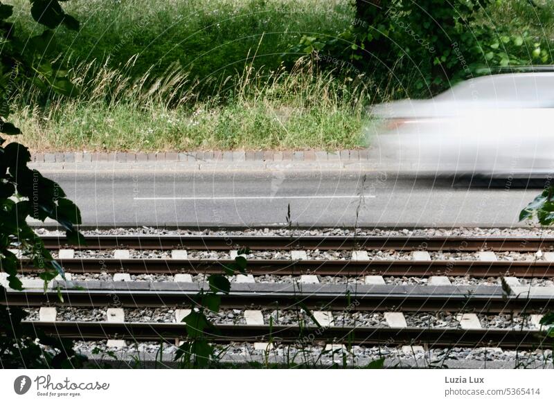 Tracks and road, a gray sedan is traveling at high speed.... light rail Transport Railroad tracks Rail transport Driving Track bed Summer Summery motion blur