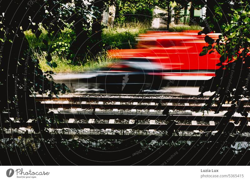 Tracks and road, a red fire truck is going way too fast.... light rail Transport Railroad tracks Rail transport Driving Track bed Summer Summery motion blur