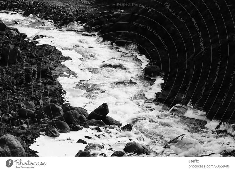 flowing water at the foot of a waterfall in Iceland Icelandic Water cascade Current Flow fluid natural force Force of nature waterfall neckline freezing cold