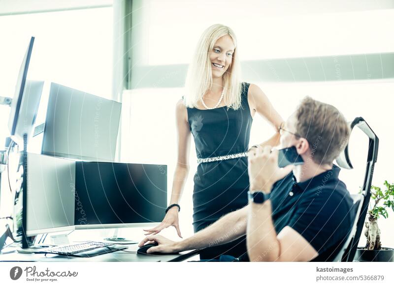 Business people looking at data on multiple computer screens, solving business issue at business meeting in modern corporate office. Business success concept.