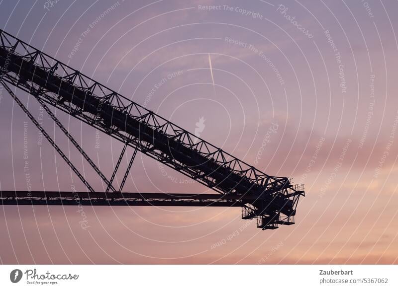 View on boom of a conveyor bridge in front of evening sky with condensation trails Overburden conveyor bridge romantic Violet Outrigger far Large f60 Industry