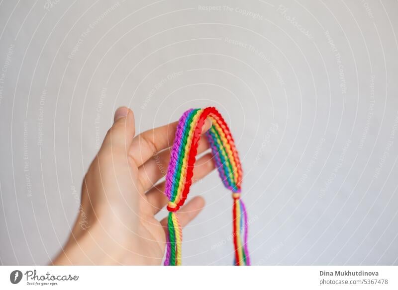 Hand holding rainbow crochet handmade bracelet. Celebrating Pride month with symbol colors of lgbt abstract art backdrop background business colorful concept