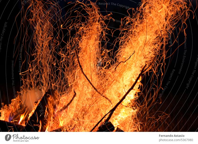 Bonfire. Small campfire with gentle flames beside a lake during a glowing sunset. San Juan night on the beach. People jumping over the bonfires. Bonfire at night.