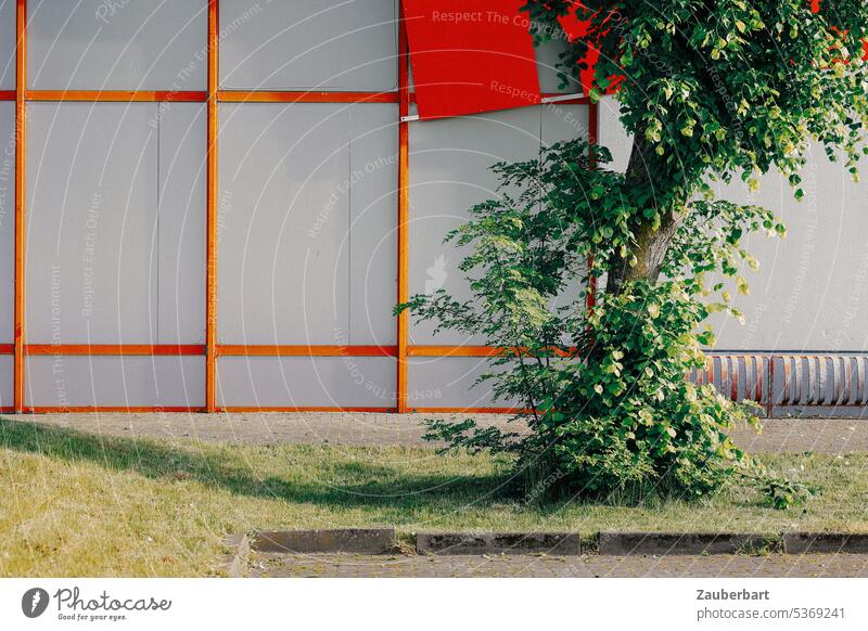 Facade with red rectangles in industrial area, in front of it tree Rectangle Red edge Industrial zone Commerce Markets Hall Warehouse Tree Building Industry