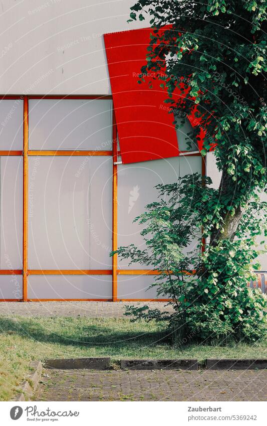 Facade with red rectangles in industrial area, in front of it tree Rectangle Red edge Industrial zone Commerce Markets Hall Warehouse Tree Building Industry