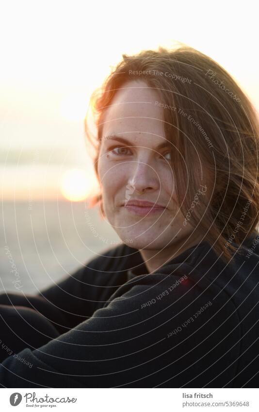 SUNLIGHT - GRIN - EVENING MOOD Woman Sunset Brunette Short-haired Nose ring Hair on the face windy Sunlight Grinning pretty Adults portrait Colour photo Smiling