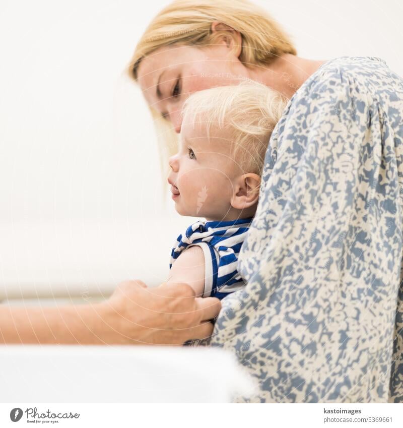 Child beeing vaccinated by pediatrician in presence of his mother. Preventive vaccination against Diphtheria, whooping cough, tetanus, hepatitis, haemophilus influenzae, pneumococcus, poliomyelitis