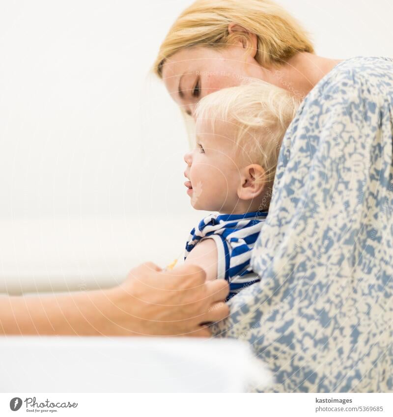 Child beeing vaccinated by pediatrician in presence of his mother. Preventive vaccination against Diphtheria, whooping cough, tetanus, hepatitis, haemophilus influenzae, pneumococcus, poliomyelitis