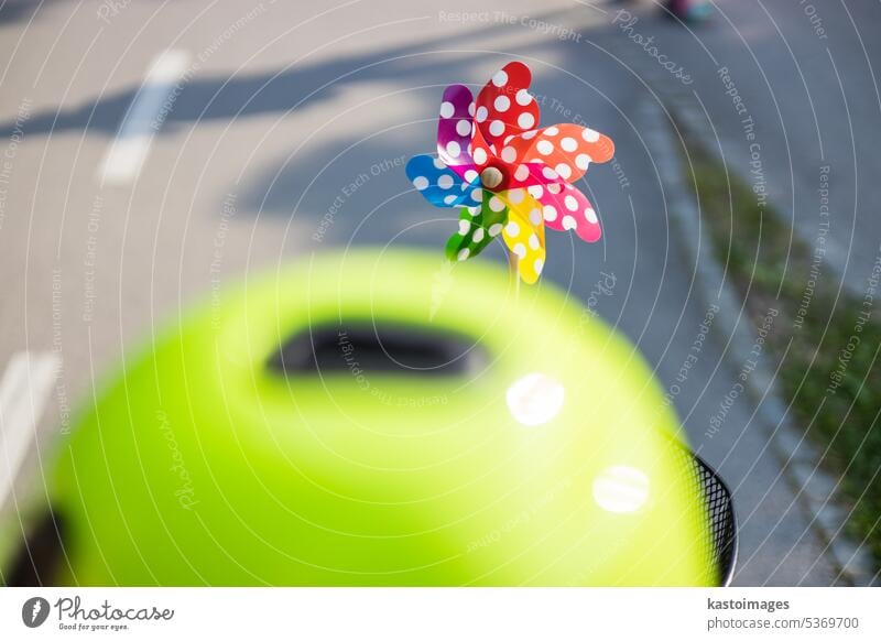 Colorful pinwheel attached to bicycle basket to entertain toddler child riding on front child seat on bike in summer. wind spinner cycling ride boy windmill man