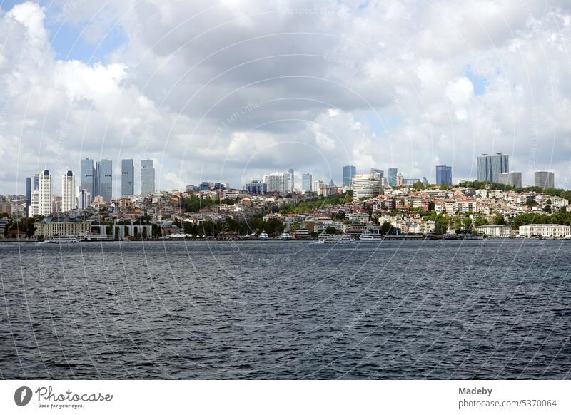 View from the ferry to Üsküdar to Dolmabahce Palace in Besiktas district in summer with clouds and sunshine in Istanbul on the Bosporus in Turkey far vision