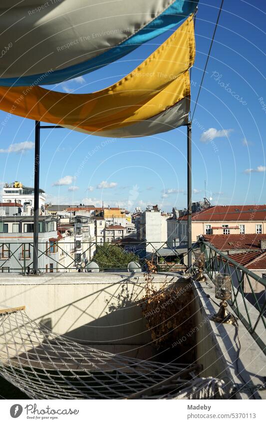 Old wooden chair, hammock and green artificial grass on the roof terrace of a hotel in Taksim district in summer sunshine on Istiklal Caddesi in Istanbul on the Bosphorus in Turkey