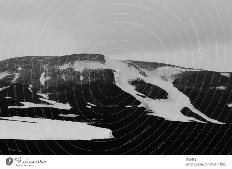 Snow forms on a hill on a gray day in Iceland North Iceland residual snow Snow melt Hill Northeast Iceland Rock mound hilly natural forms iceland trip silent