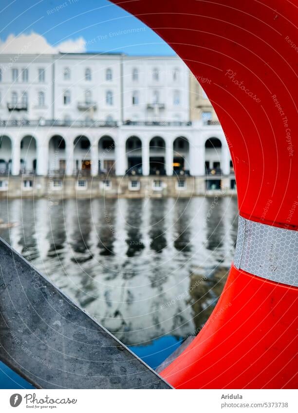 View through a life preserver at the Jungfernstieg Life belt Water Hamburg blurriness Reflection Sky Blue sky Architecture Town small alster alster arcades