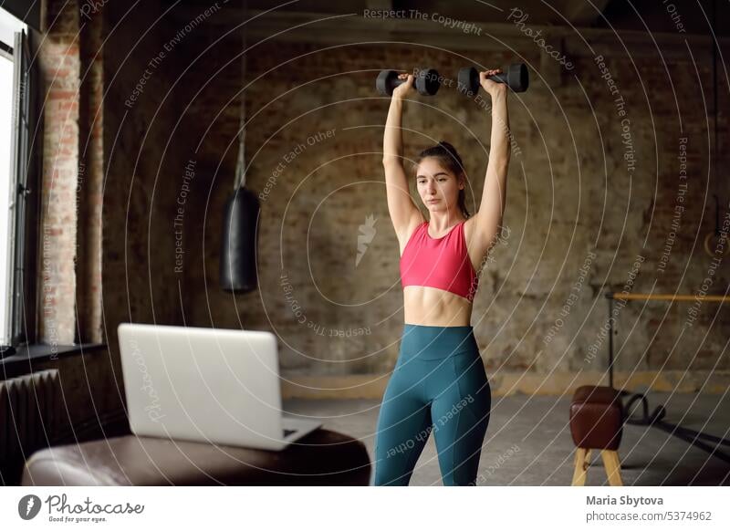 Girl trainer leads online fitness class.Young woman doing workout by laptop. Regular sports boosts immune system and promote good health and resistance to diseases.