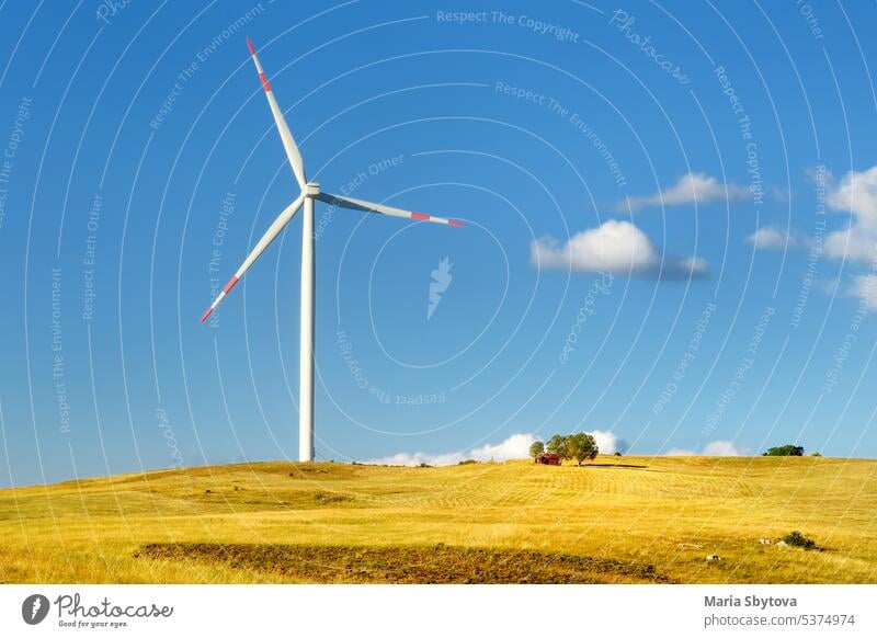 Power stations for renewable electric energy production. Windmill on sunny summer day. High wind turbine for generation electricity. Alternative energy