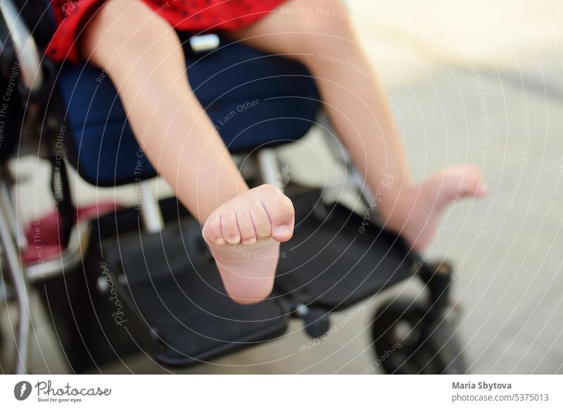 Disabled girl sitting in wheelchair. Close up photo of her legs spasticity muscles . Child cerebral palsy. Disability. Inclusion. disabled child adopted