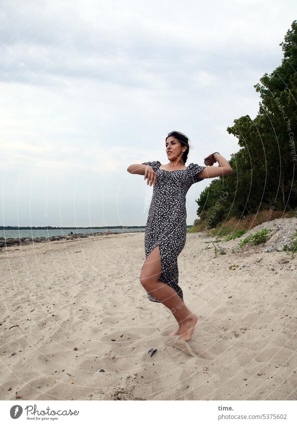 Woman on the beach throwing a stone towards the water Beach Baltic Sea Force Movement Dress Dark-haired Long-haired Braids Sand fun Litter preparation Throw