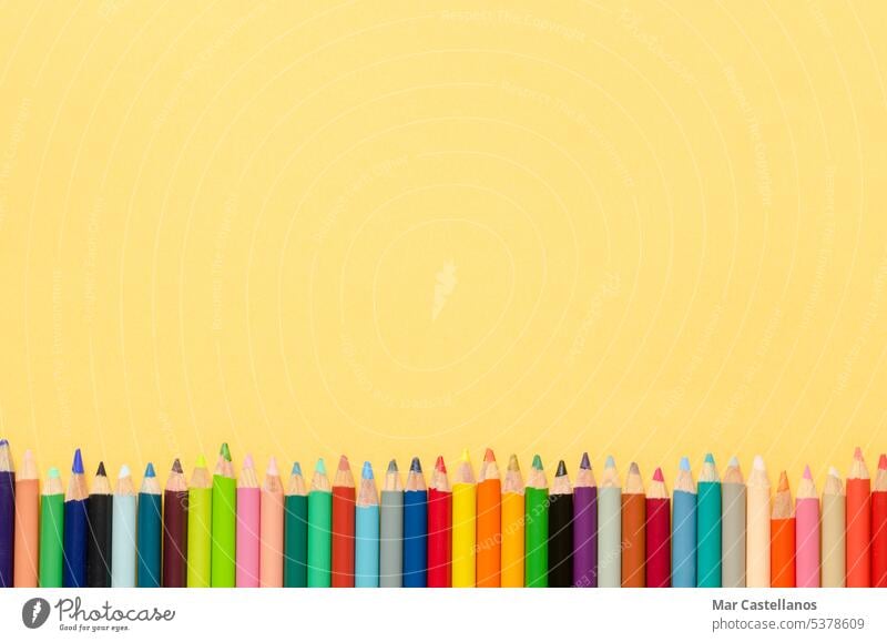 Back to class. Coloured pencils on yellow background. Copy space. Top view. Back to school envelope copy cream pastel education primary secondary text creative