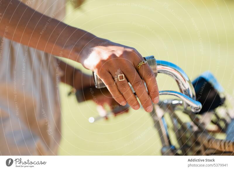 Unrecognizable woman with hands on bicycle handlebar basket road vehicle countryside transport metal summer female daylight daytime bike stand outside lady