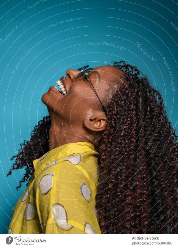 Excited stylish woman with heavy curly hair and head up laugh happy excited cheerful eyes closed head raised having fun humor enjoy glad smile female black