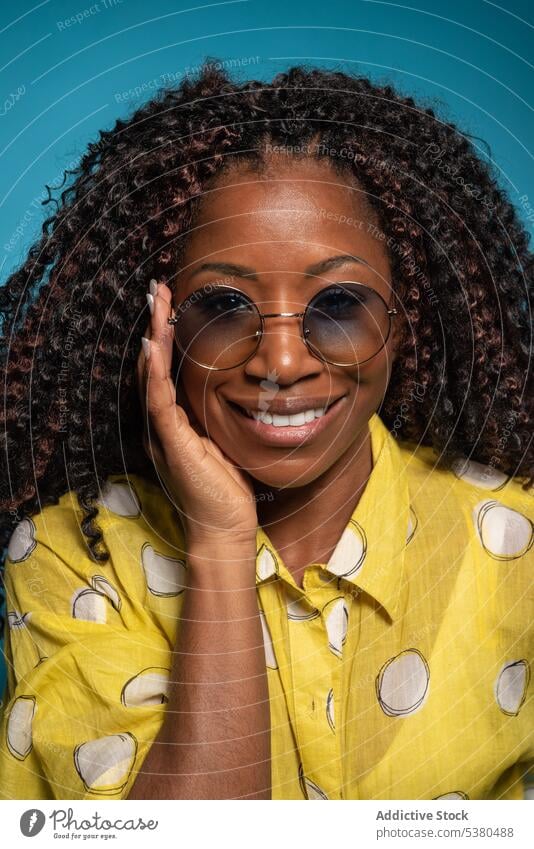 Happy elegant woman with curly hair looking at the camera laugh happy excited cheerful having fun humor enjoy glad smile female black african american