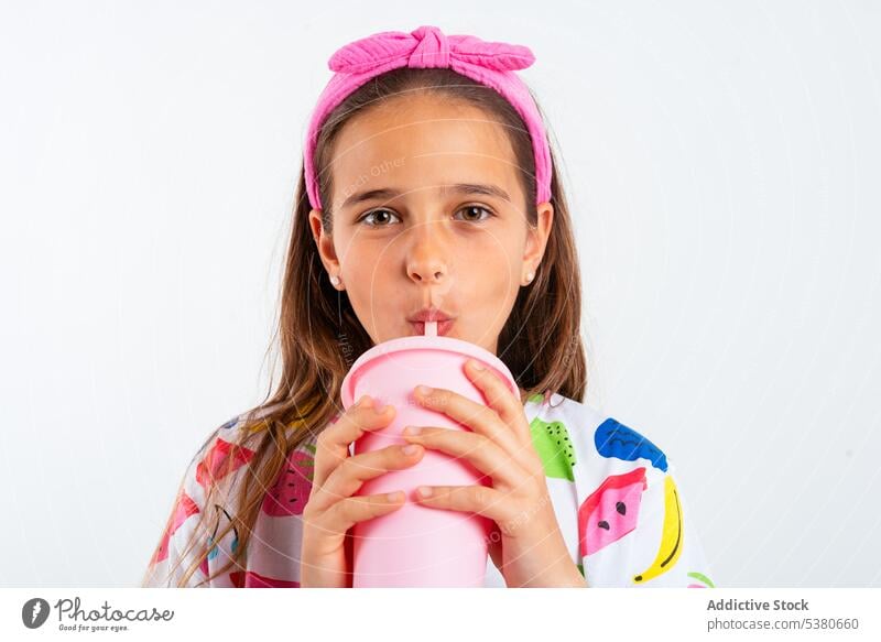 Girl with plastic cup of milkshake girl smile positive happy drink little childhood glad headband kid optimist content studio shot healthy refreshment pure