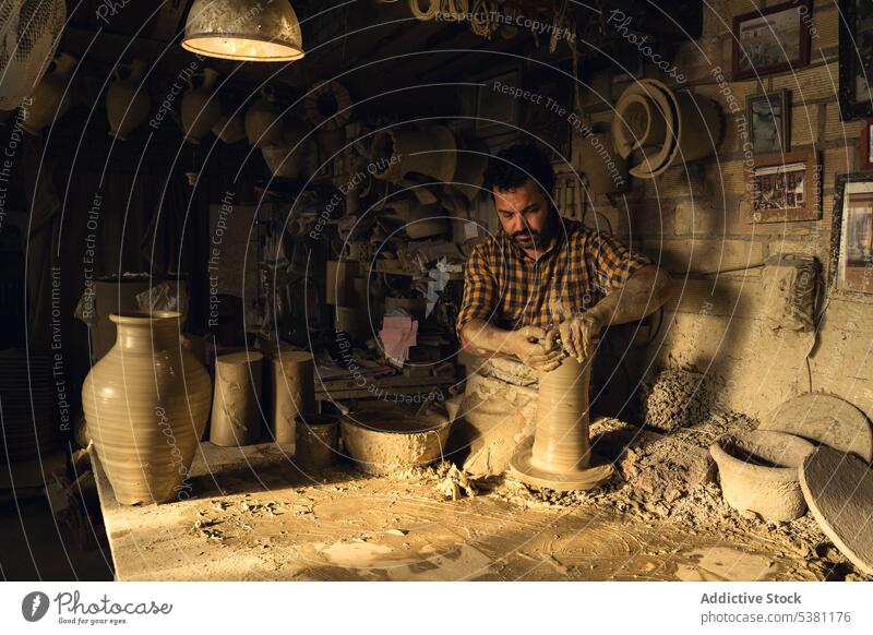 Ethnic ale artisan creating pot on wheel in local workshop man pottery pottery wheel craftsman create master shape skill occupation male ethnic adult process