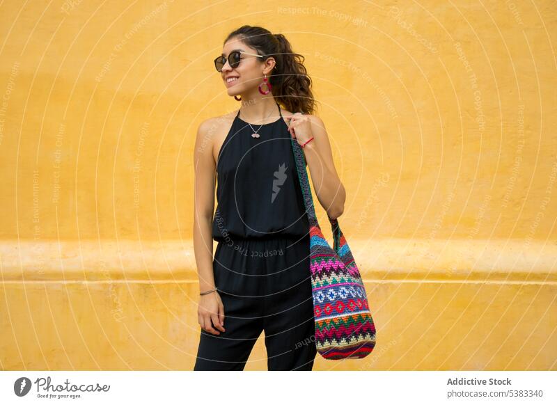 Happy young woman with bag smile happy style outfit wall knitted ornament sunglasses mexico san cristobal de las casas chiapas colorful fashion trendy cheerful