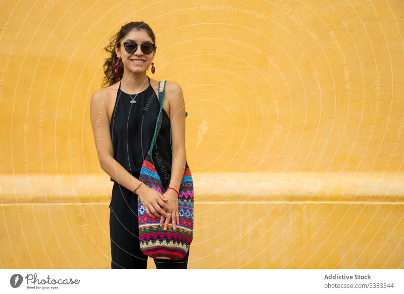 Happy young woman with bag smile happy style outfit wall knitted ornament sunglasses mexico san cristobal de las casas chiapas colorful fashion trendy cheerful