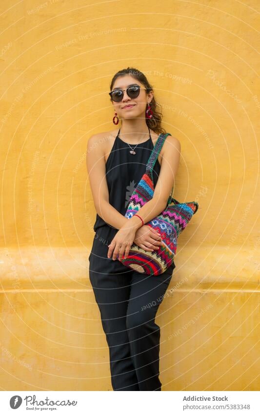 Positive young woman with bag style outfit wall knitted ornament sunglasses mexico san cristobal de las casas chiapas colorful fashion trendy bright positive