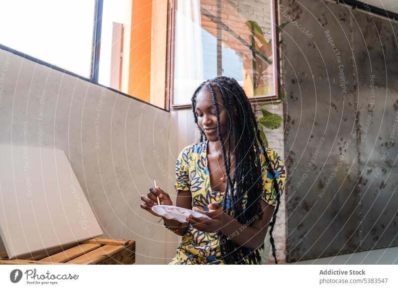 Woman painting with watercolor in workshop painter woman artist palette artwork creative smile skill happy paintbrush african american studio female craft