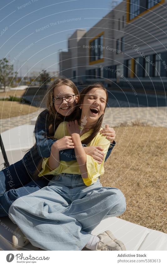 Happy teenage girls spending leisure time in city park friend together hug embrace portrait smile friendship happy casual positive teenager young carefree