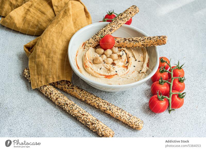 Hummus, tomatoes and bread sticks served in a bowl cherry tomato cuisine dinner dish food healthy hebrew hummus israel lunch oil organic plant based rice bread